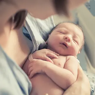 Nouveau-né endormi dans les bras de sa mère