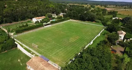 Vue aérienne d'un terrain de football engazonné bordé d'arbres