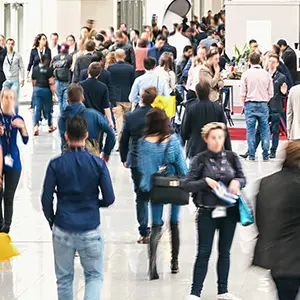 Foule de visiteurs circulant dans les allées d'un hall d'exposition