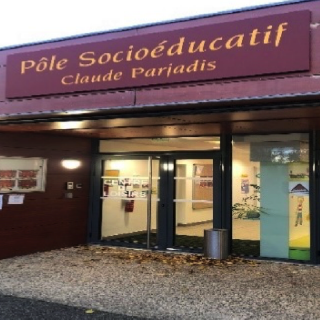 Entrée vitrée du pôle socio-éducatif, sous son enseigne
