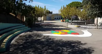 Cour de l'école maternelle Marcel Pagnol, avec ses gradins et un escargot coloré peint au sol