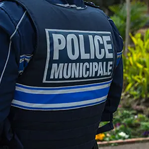 Agent de police municipale vu de dos, gilet marqué « Police municipale »