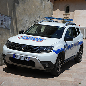Véhicule sérigraphié de la police municipale stationné dans une rue pavée