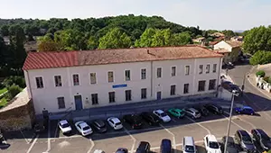 Vue aérienne de l'espace Acampado, bâtiment au toit de tuiles bordé d'un parking