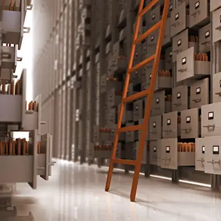 Allée d'une salle d'archives avec une échelle et des tiroirs de classement