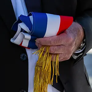 Écharpe tricolore à franges dorées tenue à la main par un élu